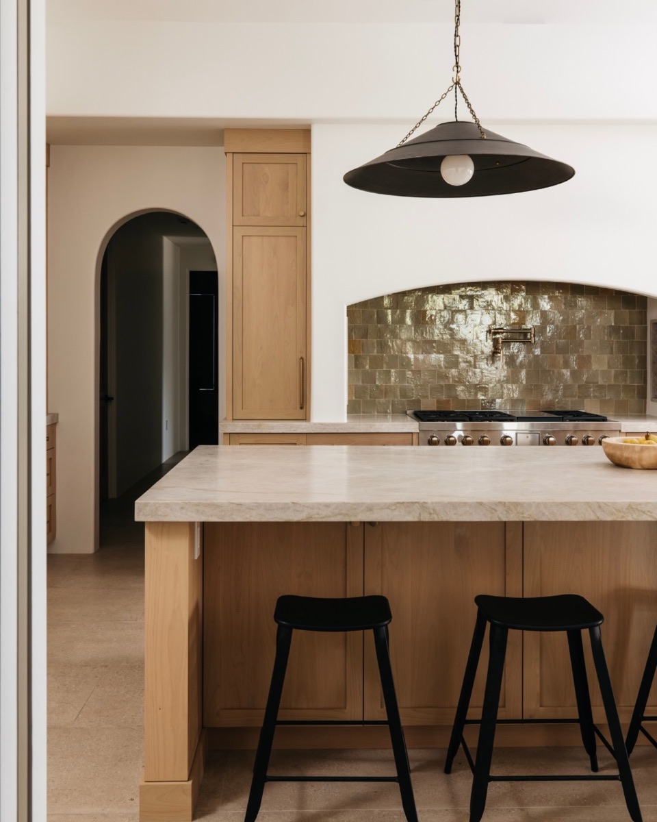 Warm wood kitchen with an arched doorway and sculptural pendant
